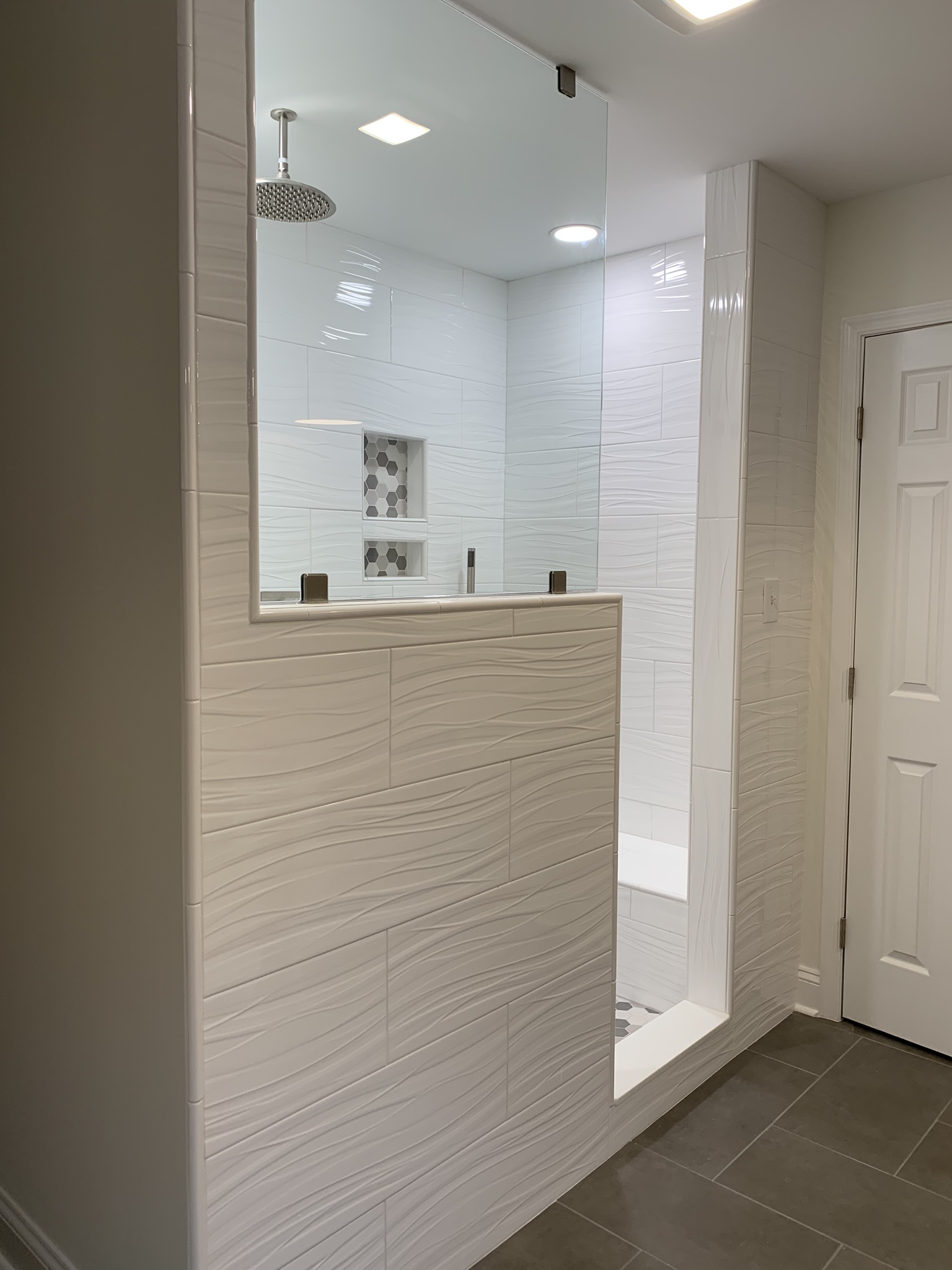 European-style walk-in shower with frameless glass and decorative tile